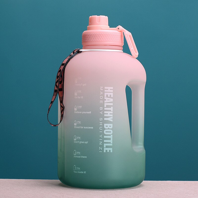 Grosse, farbverlaufende Trinkflasche in Pink und Gruen mit einem Fassungsvermoegen von 3 Litern, versehen mit einem Tragegriff und motivierenden Zeitmarkierungen vor einem gruenen Hintergrund.