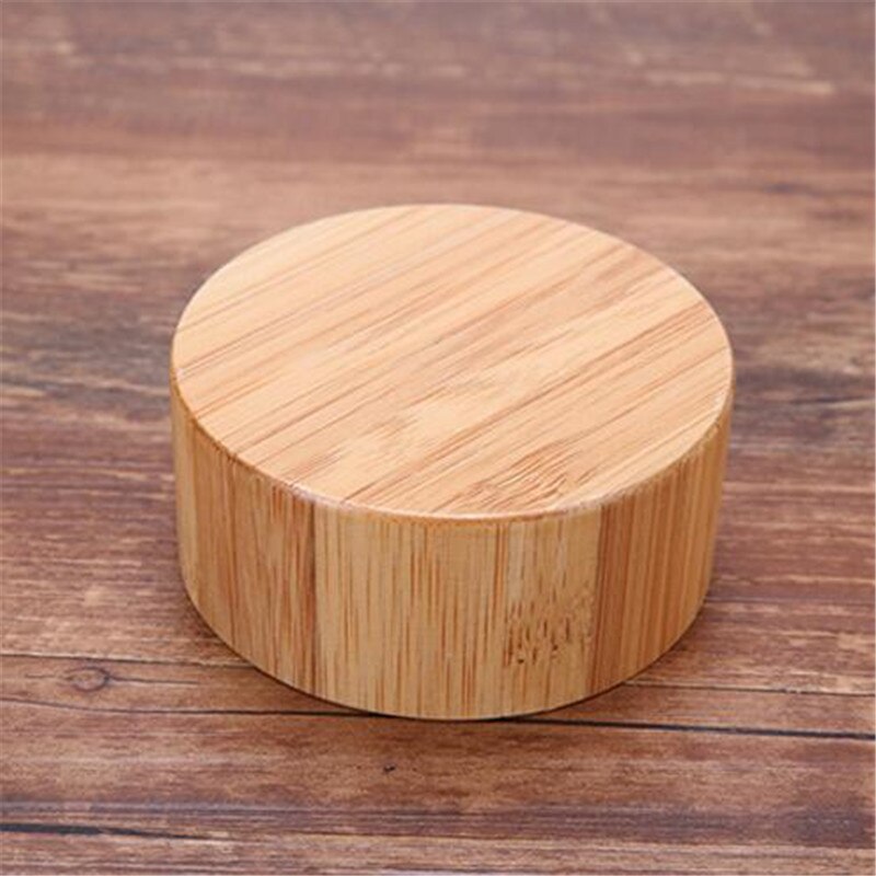 Ein runder Bambusdeckel mit natuerlicher Maserung, liegt auf einer Holzoberflaeche.
