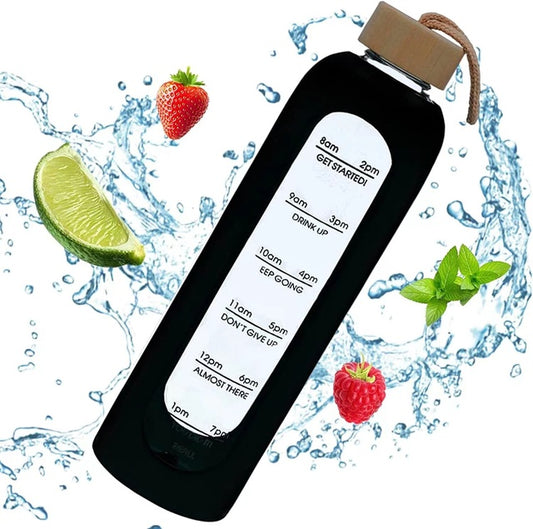 Eine schwarze Glastrinkflasche mit weisser Zeitmarkierung und Bambusdeckel, umgeben von Wasserspritzern, Erdbeere, Limette und Minze.