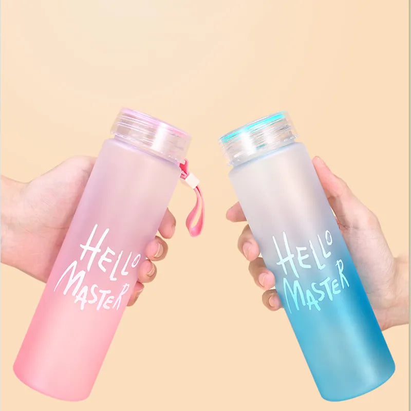 Zwei Händen, die jeweils eine Sport-Trinkflasche halten, eine rosa und eine blau gefärbte, beide mit der Aufschrift "Hello Master".