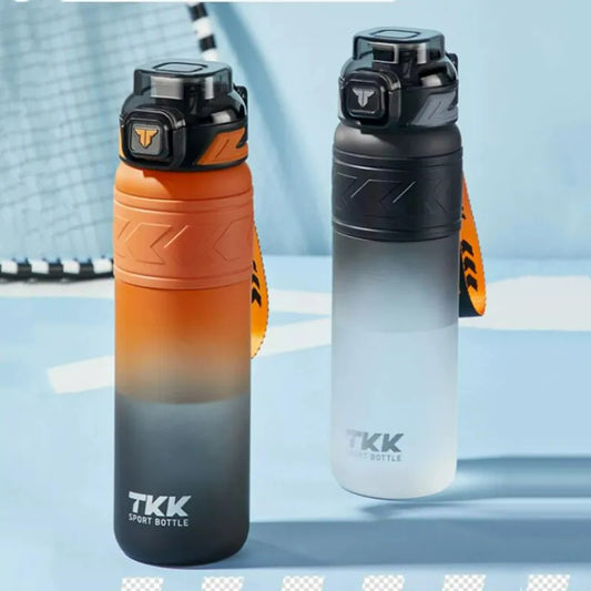 Zwei Sport-Trinkflaschen mit Farbverlauf, eine in Orange zu Schwarz und die andere in Grau zu Transparent, mit dem Logo 'TKK' auf einem hellblauen Hintergrund, in einer Sportumgebung.