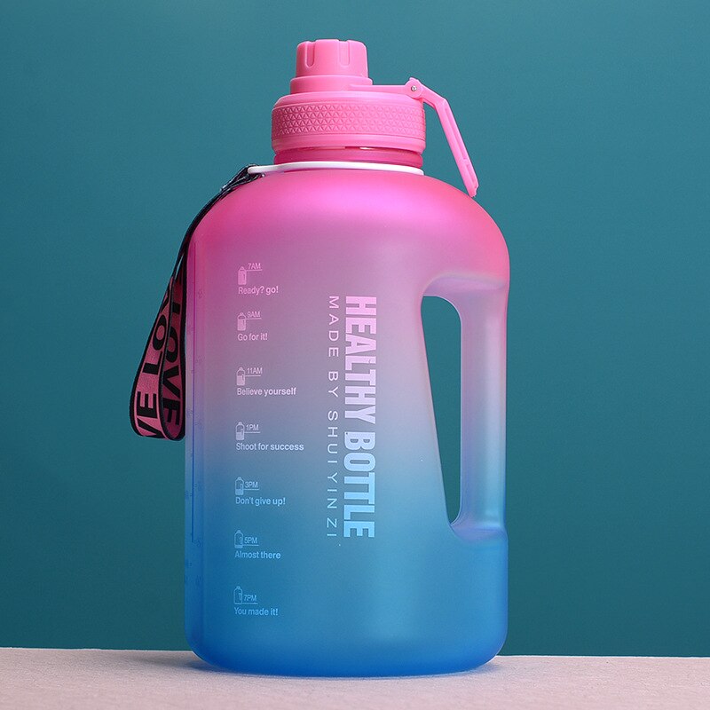Grosse, farbverlaufende Trinkflasche in Pink und Blau mit einem Fassungsvermoegen von 3 Litern, versehen mit einem Tragegriff und motivierenden Zeitmarkierungen vor einem gruenen Hintergrund.