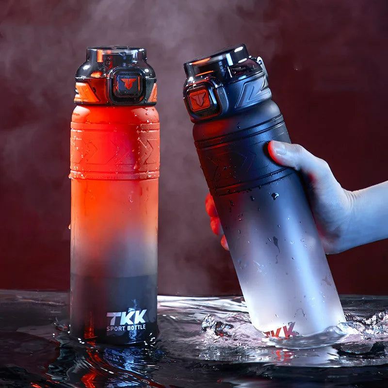 Zwei 1-Liter-Sport-Trinkflaschen, eine mit einem Farbverlauf von Rot zu Schwarz und die andere von Dunkelblau zu Transparent, beide mit tropfendem Wasser, das die Flaschen umgibt.