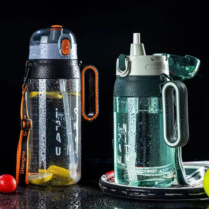 Zwei gefuellte Sport-Trinkflaschen mit Strohhalm und Kondenswasser an der Außenseite, eine mit einem orangefarbenen und die andere mit einem grauen Griff, auf einem dunklen Hintergrund mit leuchtenden Wassertropfen.
