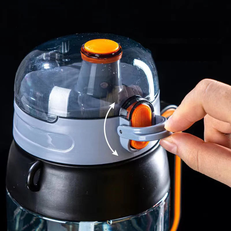 Eine Nahaufnahme einer Sport-Trinkflasche mit einem grauen und orangefarbenen Deckel. Eine Hand öffnet den orangefarbenen Sicherheitsverschluss des Strohhalms.