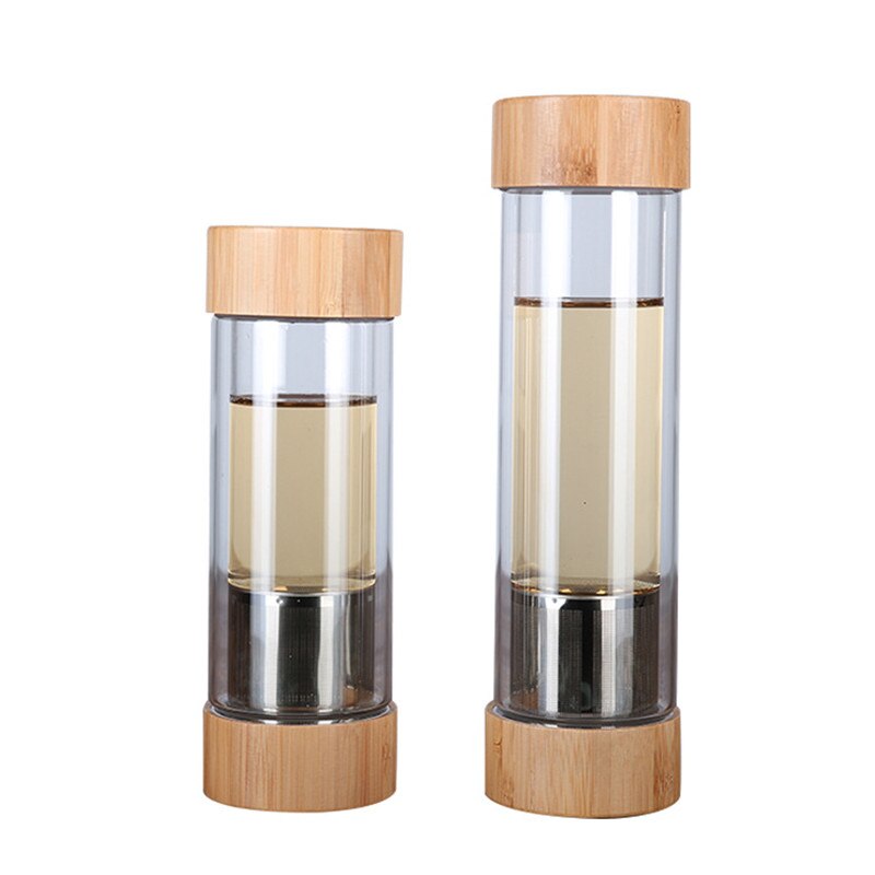 Zwei transparente Glastrinkflaschen mit Tee, ausgestattet mit Edelstahlsieben und Bambusdeckeln, stehen nebeneinander.