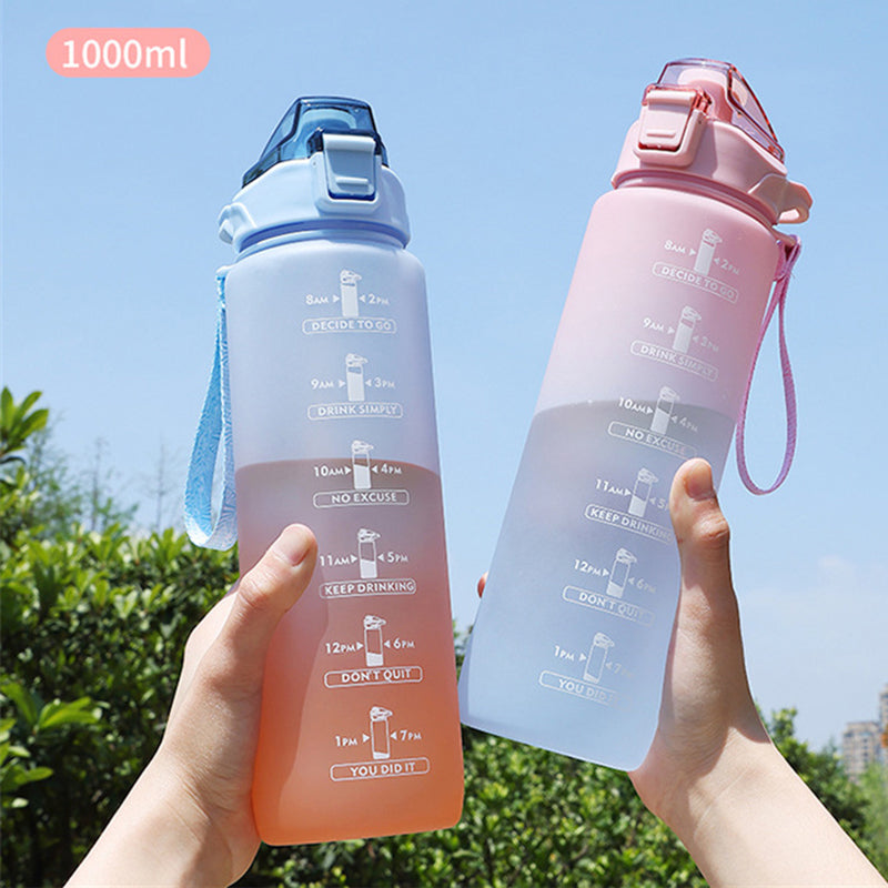 Zwei Haende halten je eine 1000ml Trinkflasche mit Zeitmarkierungen hoch, die eine in Blau, die andere in Orange, vor einem sonnigen Hintergrund mit blauem Himmel und gruener Vegetation.