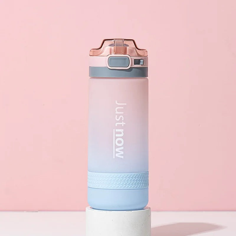 Eine farbverlaufende Trinkflasche mit der Aufschrift "Just now" vor einem pinkem Hintergrund.