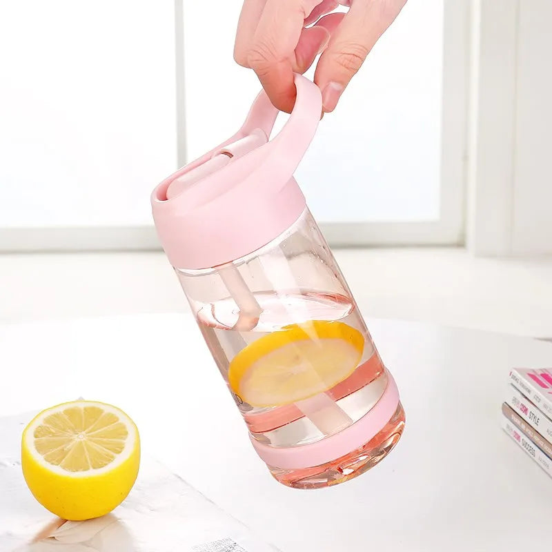 Eine Hand hebt eine transparente, pinkfarbene Trinkflasche mit Wasser und Zitronenscheiben, neben einer halbierten Zitrone.