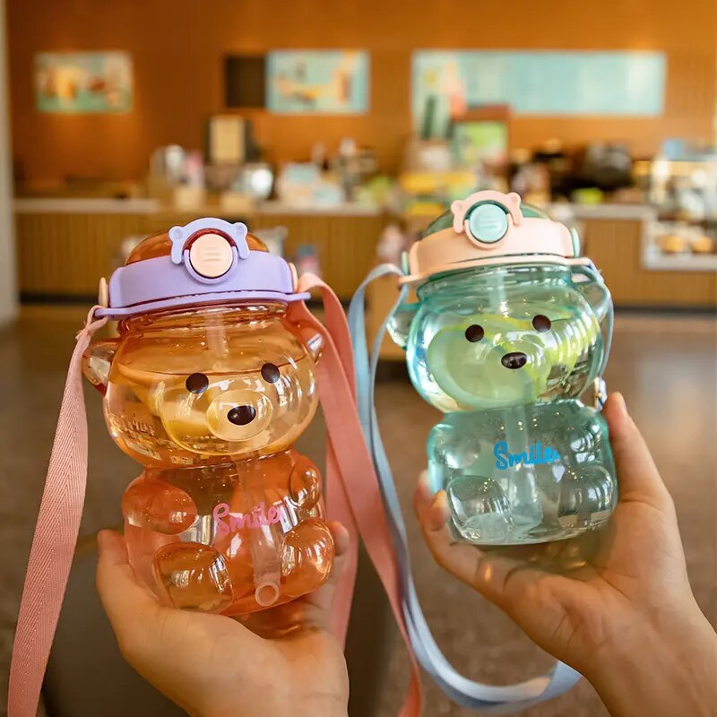 Zwei bunte Teddybaer-Wasserflaschen fuer Kinder mit Trageschlaufen.