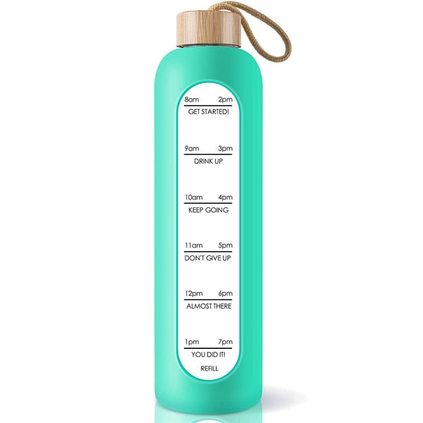 Eine gruene Glastrinkflasche mit Zeitmarkierungen und einem Bambusdeckel, versehen mit einem Jute-Trageband.