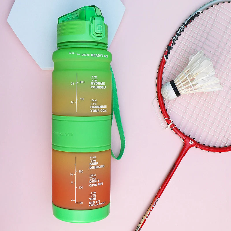 Eine gruene Wasserflasche mit motivierenden Zeitmarkierungen für den ganzen Tag, neben einem Badminton-Schlaeger und Federball auf einem rosa und weißen Hintergrund.